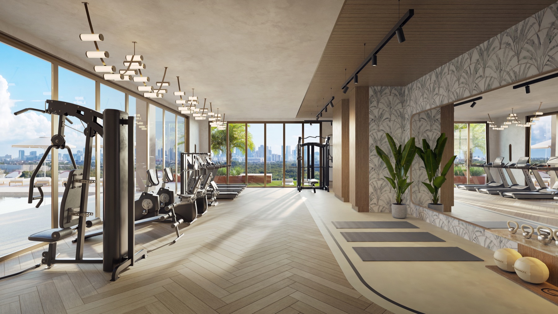 The fitness center at Seventeen Gables — a fully equipped studio with state-of-the-art equipment and free weights, framed by floor-to-ceiling glass and natural light.